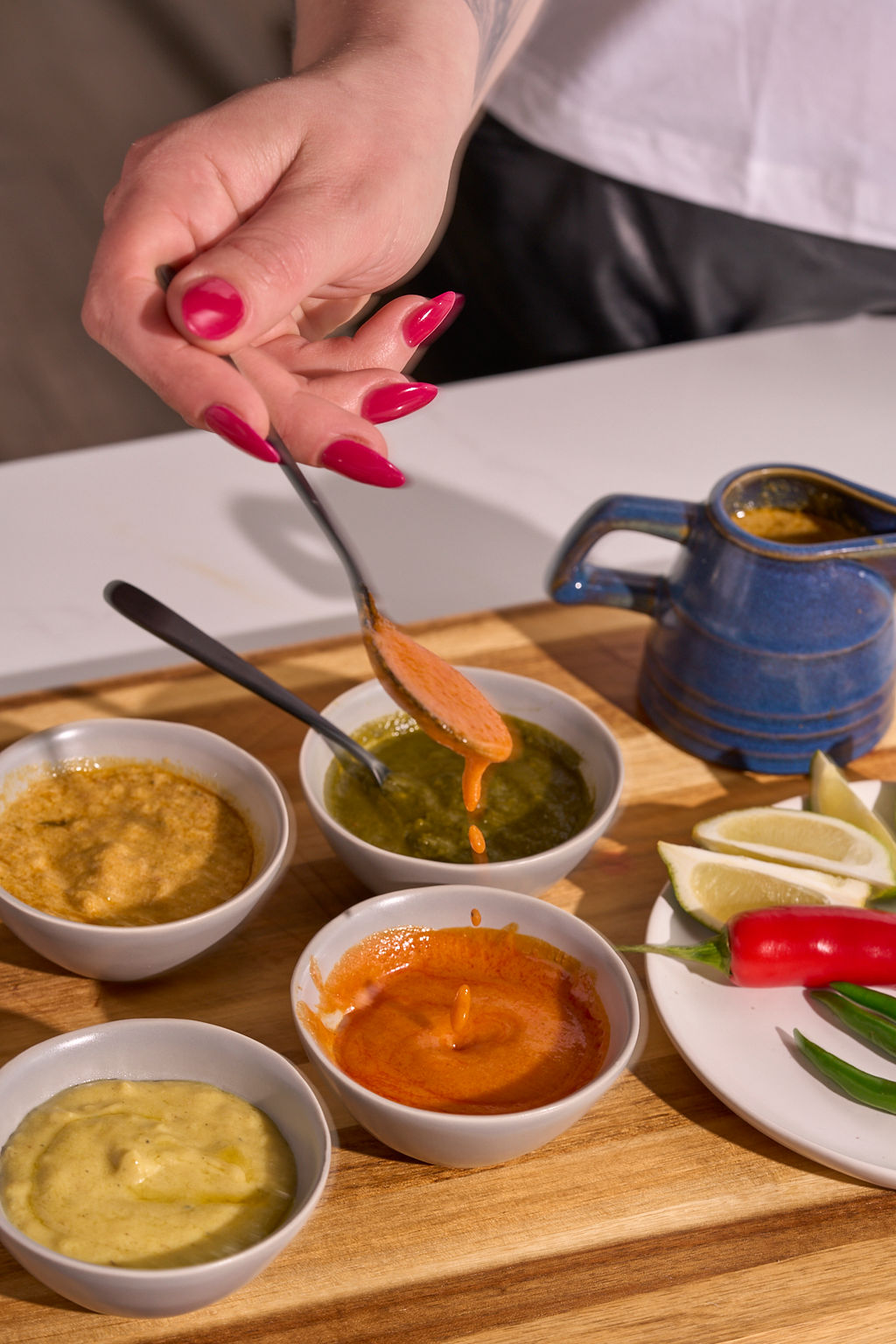 A flight of Tikka sauces being spooned